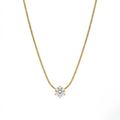 Gold necklace with a diamond pendant on a white background
