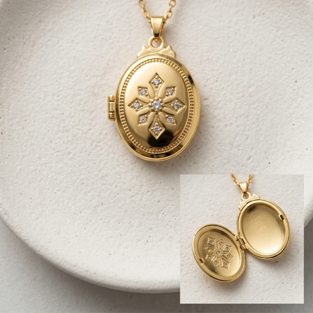 Gold oval locket pendant necklace with a floral starburst motif and clear stones, shown closed on a white textured surface with an inset showing the open locket interior.