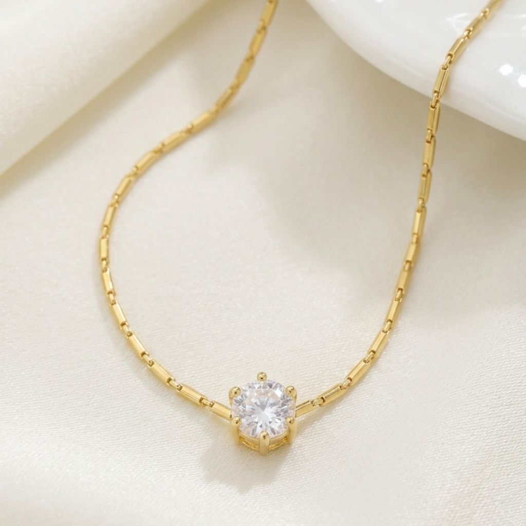 Gold necklace with a diamond pendant on a light beige background
