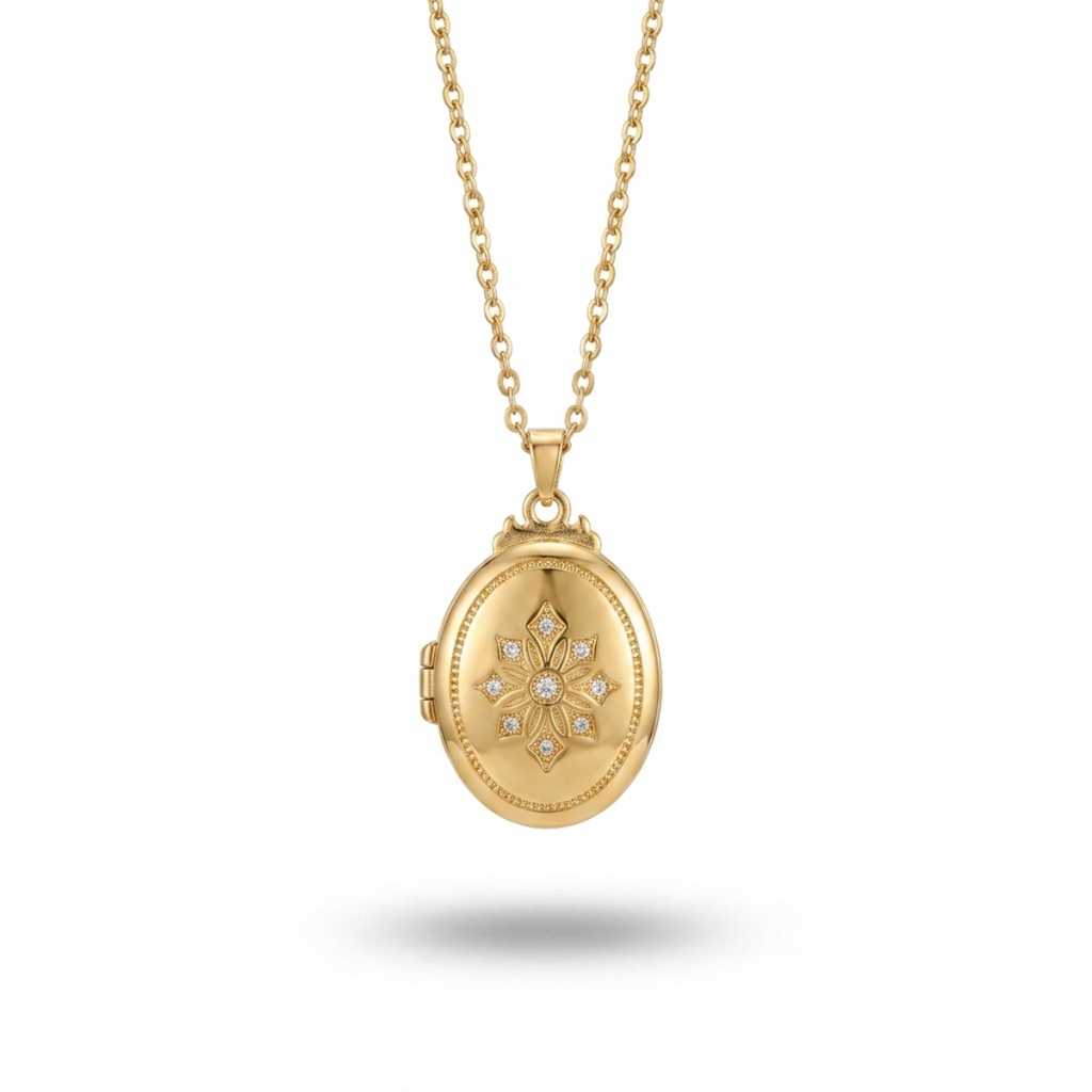 A gold oval locket necklace with a floral starburst design set with small clear stones in the center, hanging from a delicate gold chain against a white background.