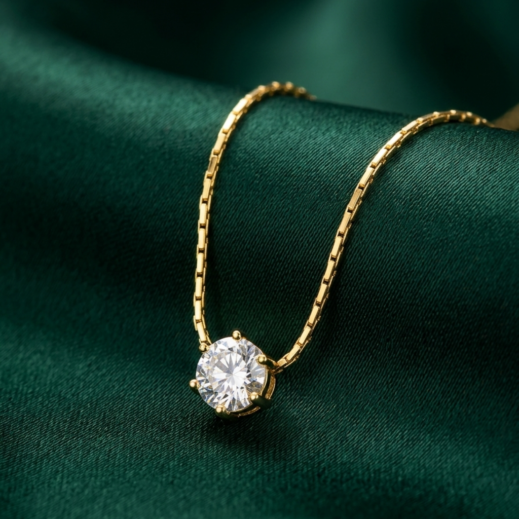 Gold necklace with a diamond pendant on a green fabric background