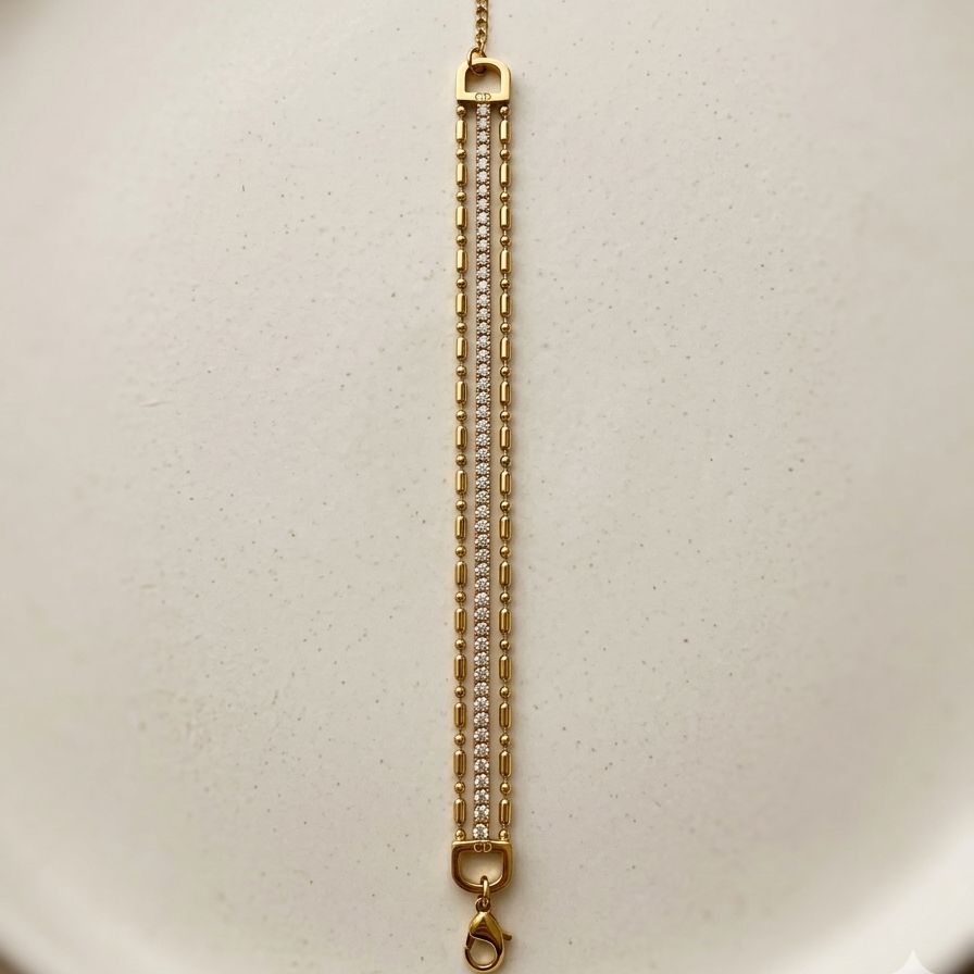 wrist wearing a layered 18k gold plated bracelet featuring delicate gold beads and a row of sparkling CZ diamonds.