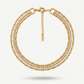 wrist wearing a layered 18k gold plated bracelet featuring delicate gold beads and a row of sparkling CZ diamonds.