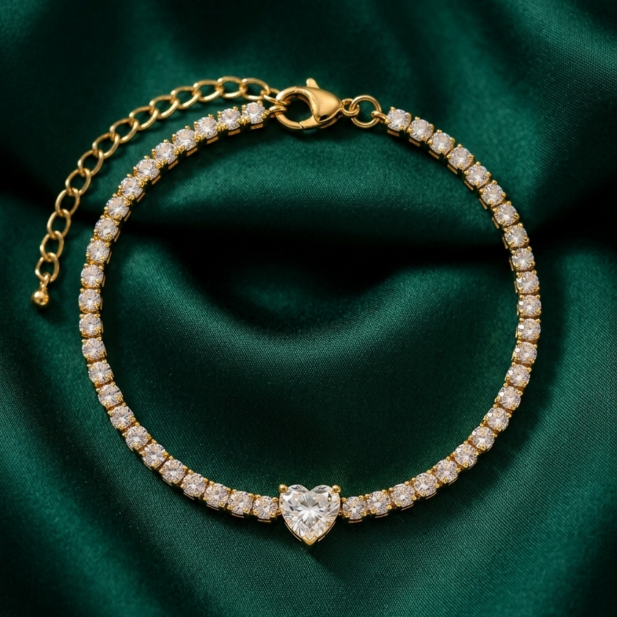 18k gold plated tennis bracelet featuring a row of CZ diamonds and a prominent heart-shaped center diamond on a green fabric background