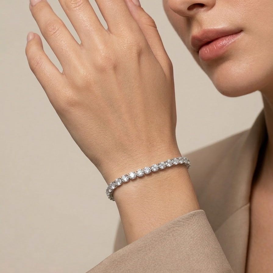 Woman wearing a premium silver-tone rhodium plated tennis bracelet featuring a continuous row of sparkling CZ diamonds and a secure box clasp on a neutral background