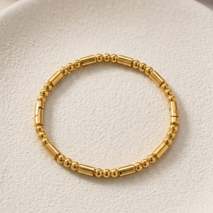 18k gold plated bracelet featuring a minimalist pattern of alternating polished gold spheres and sleek cylinder links.