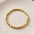 18k gold plated bracelet featuring a minimalist pattern of alternating polished gold spheres and sleek cylinder links.