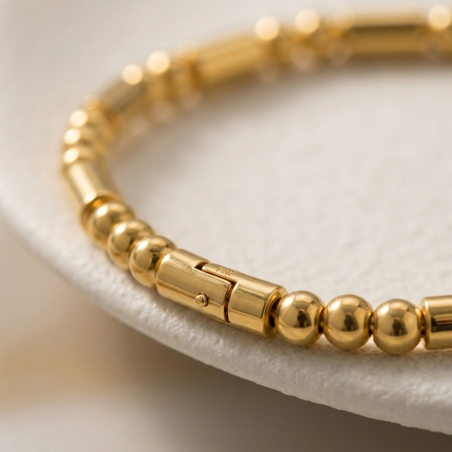 18k gold plated bracelet featuring a minimalist pattern of alternating polished gold spheres and sleek cylinder links.