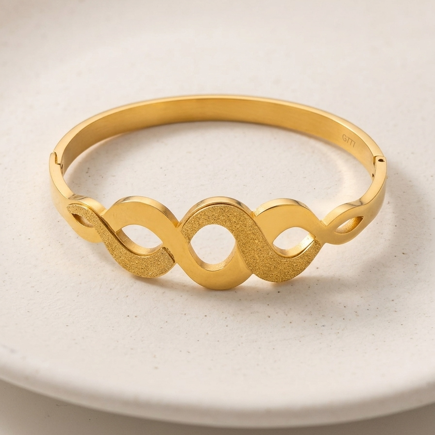 18k gold plated bangle bracelet featuring an infinity wave cutout design with alternating polished and frosted gold textures.