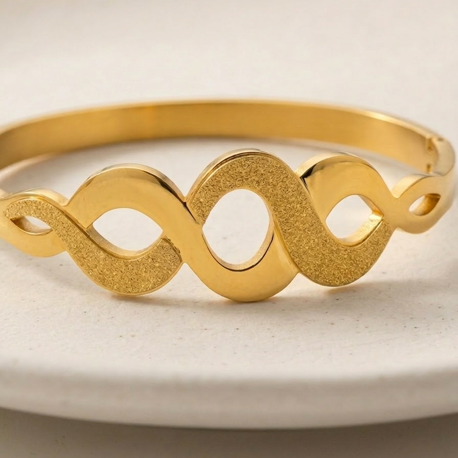 18k gold plated bangle bracelet featuring an infinity wave cutout design with alternating polished and frosted gold textures.