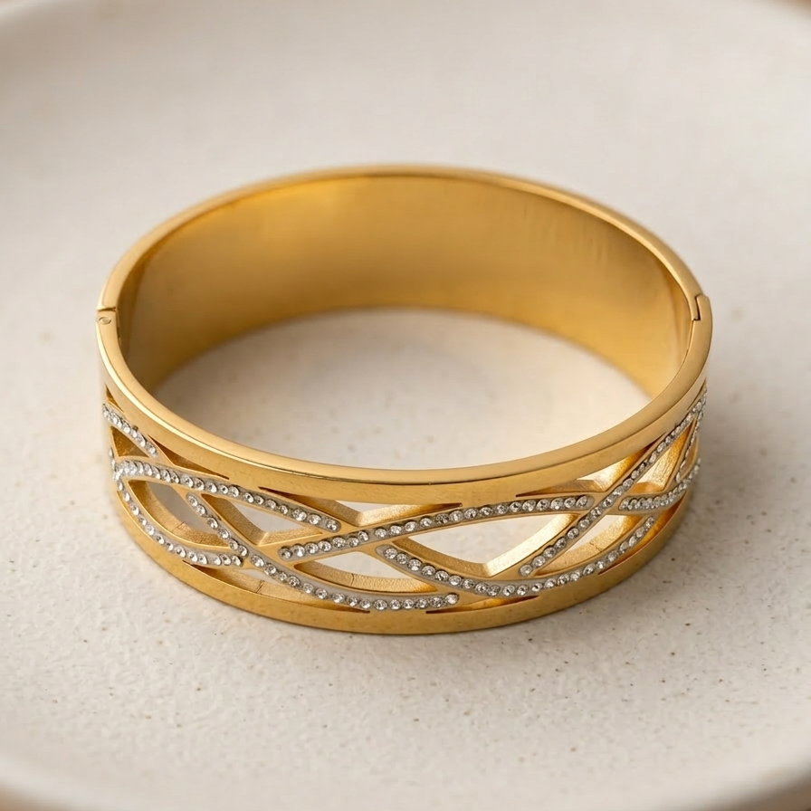 Wide 18k gold plated statement bangle bracelet featuring a criss-cross cutout pattern lined with sparkling pave CZ diamonds.