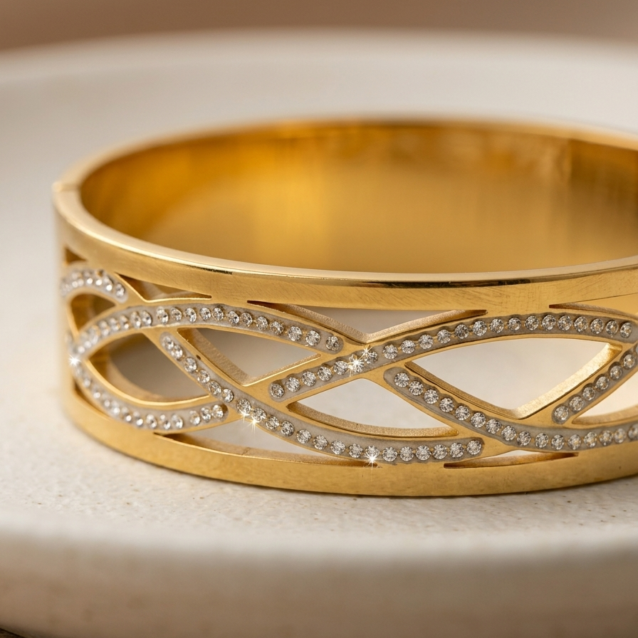 Wide 18k gold plated statement bangle bracelet featuring a criss-cross cutout pattern lined with sparkling pave CZ diamonds.