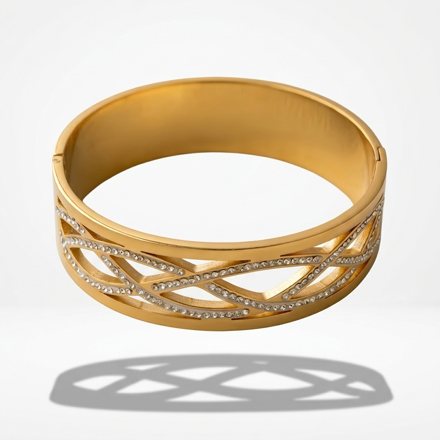 Wide 18k gold plated statement bangle bracelet featuring a criss-cross cutout pattern lined with sparkling pave CZ diamonds.