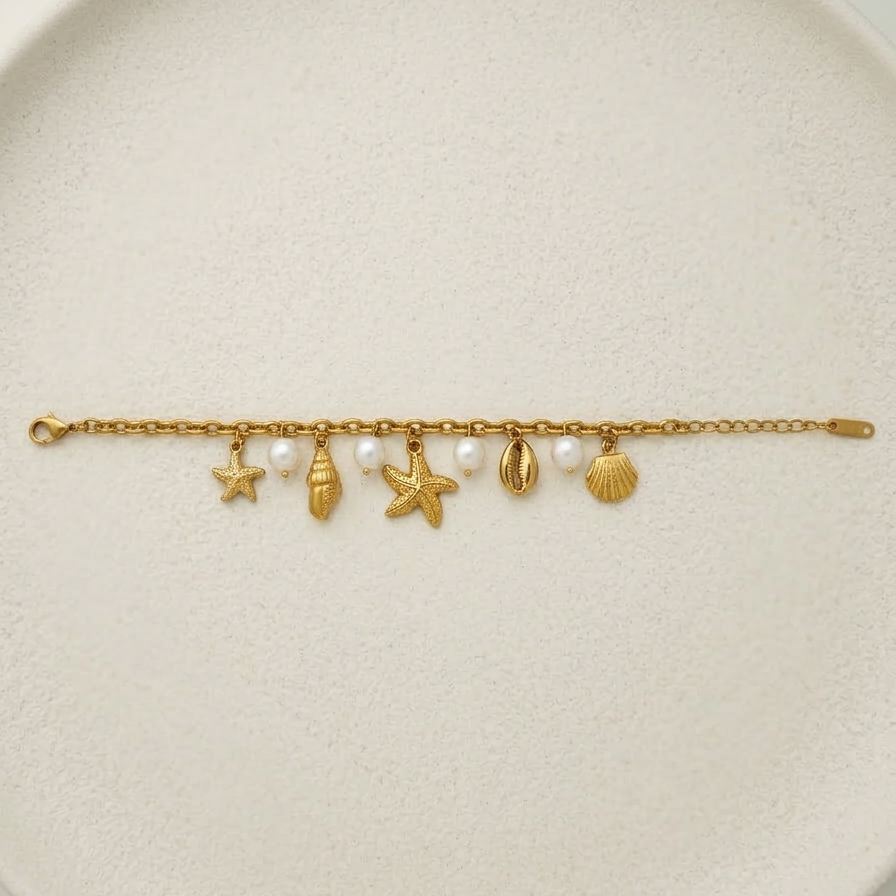 18k gold plated chain bracelet adorned with dangling charms including golden starfish, seashells, and white pearls.