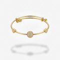18k gold plated adjustable sliding bangle bracelet featuring a central sphere covered in pave CZ diamonds and two small gold heart accents.