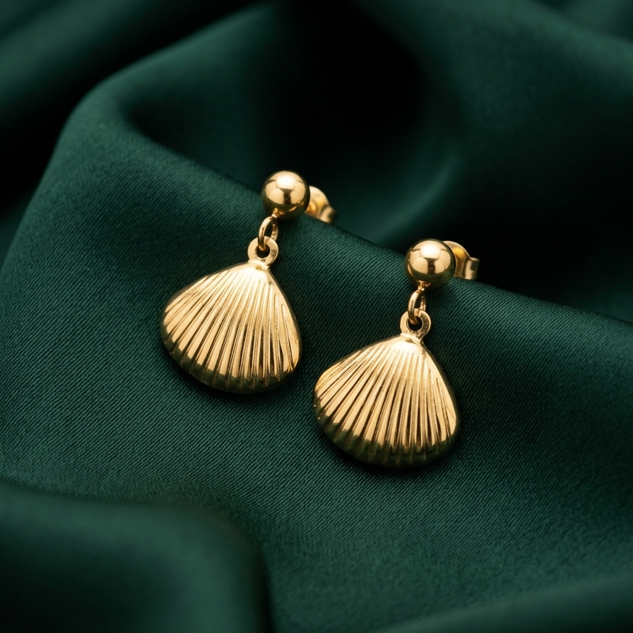 18kt gold plated shell-shaped earrings on a green fabric background.