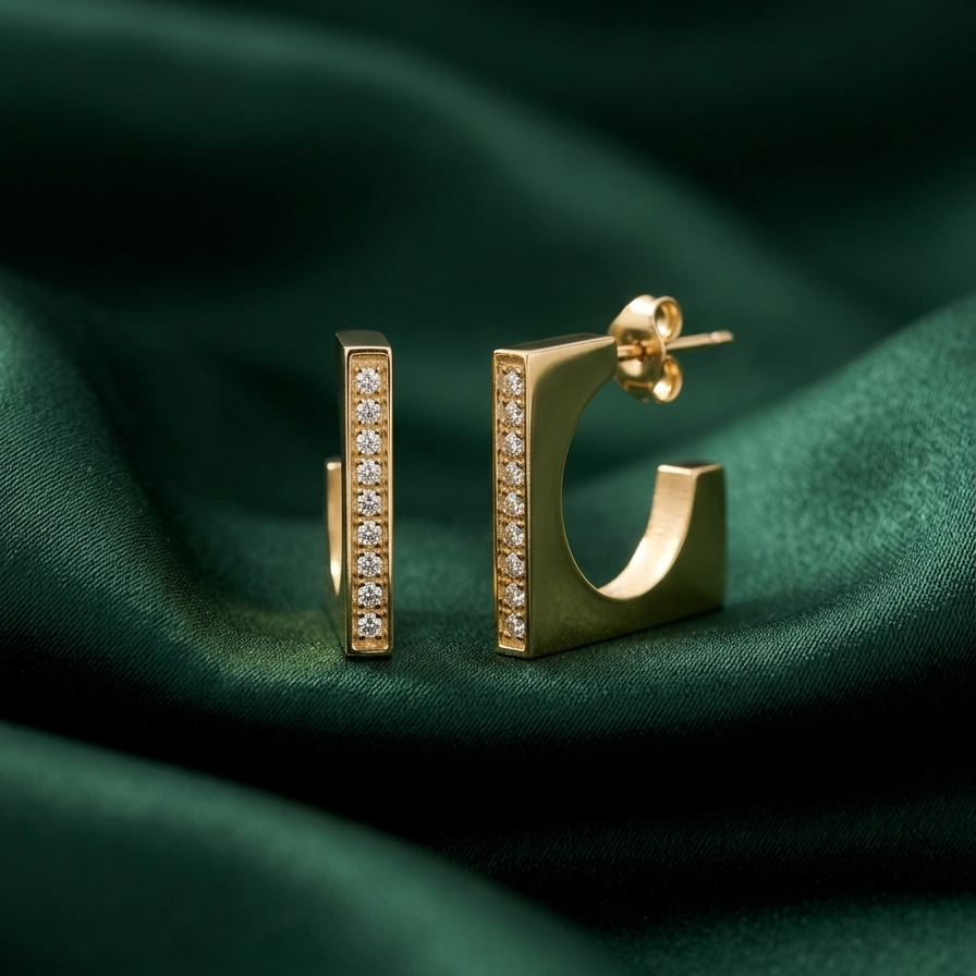 18kt gold plated hoops with diamond accents on a green fabric background.