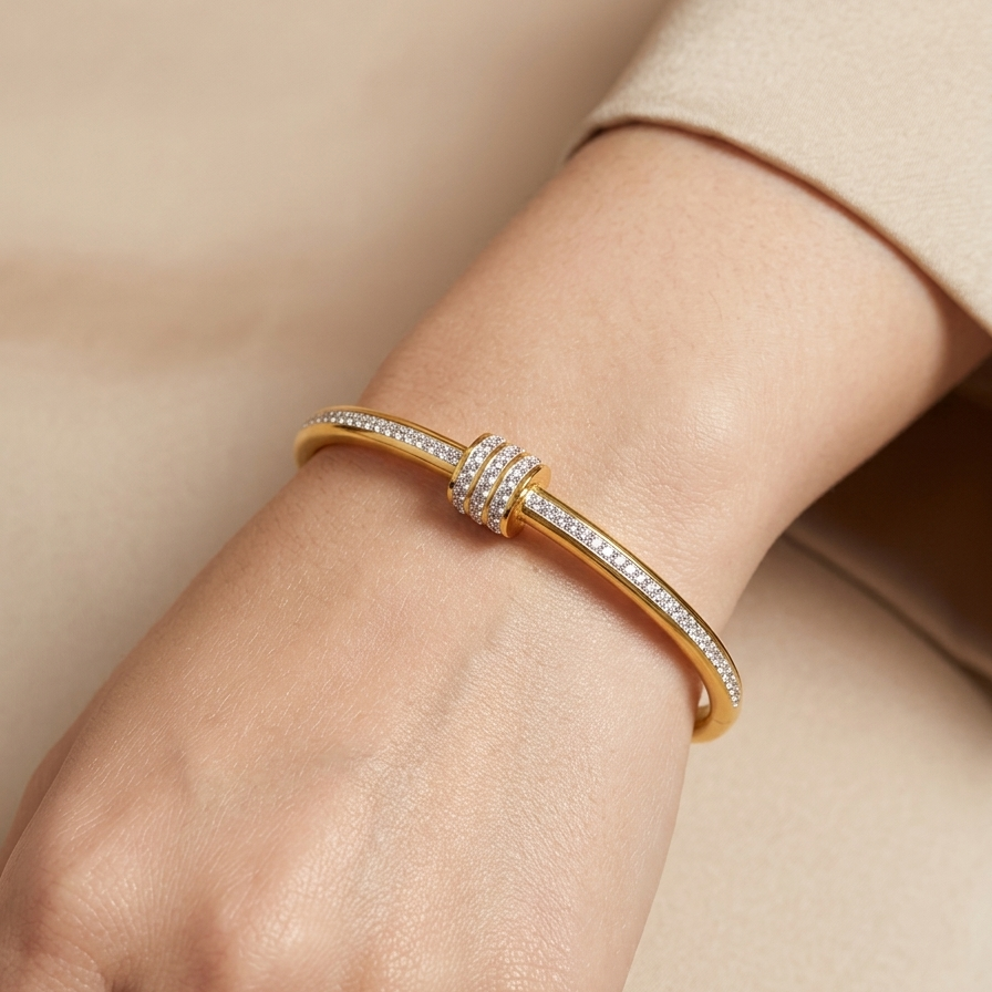 18kt gold plated roller bracelet with diamonds on a wrist against a beige background.