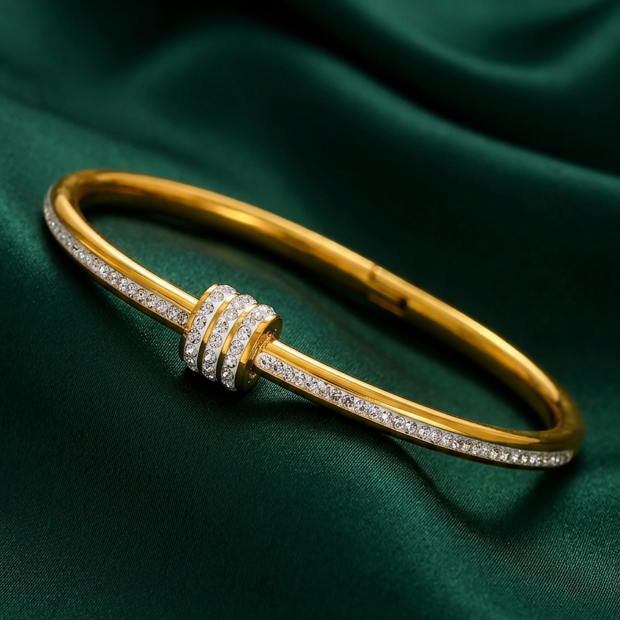 18kt gold plated diamond dust roller bangle on a green fabric background.