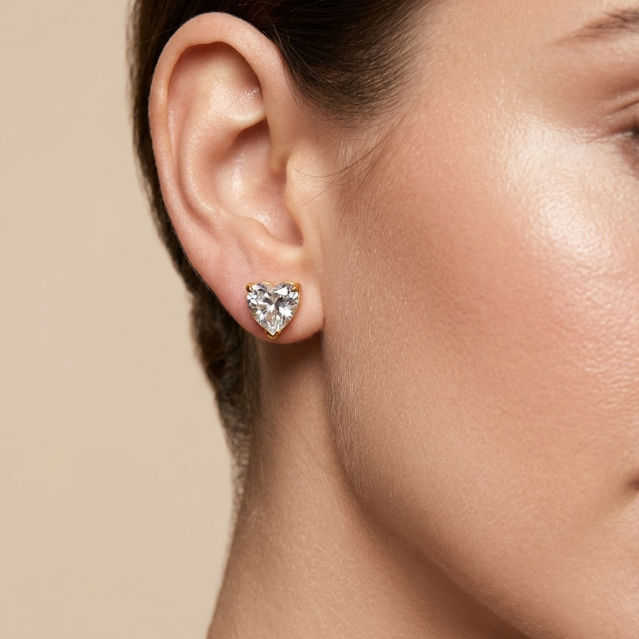 Heart-shaped earring worn by a model against a neutral background