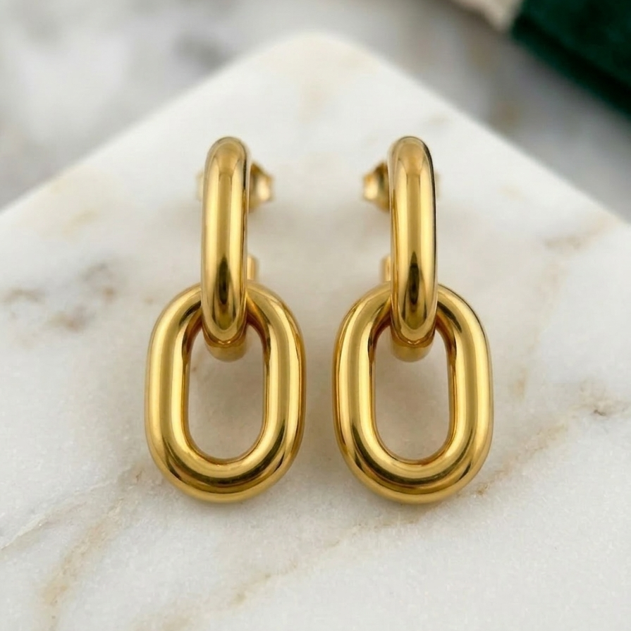 Pair of 18k gold plated drop earrings featuring two thick, interlocking oval chain links on marble surface