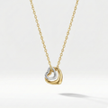 Gold necklace with double interlocking open heart pendant on beige plate.