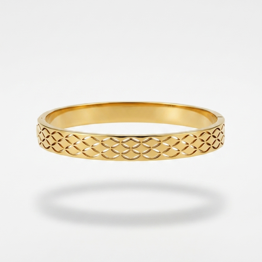 A gold bangle bracelet with an openwork geometric lattice pattern, shown against a light gray background with a soft shadow underneath.