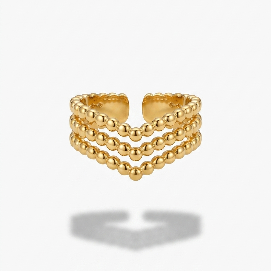 A gold-toned triple-row beaded ring with a scalloped inner edge, shown on a light gray background with a soft shadow underneath.
