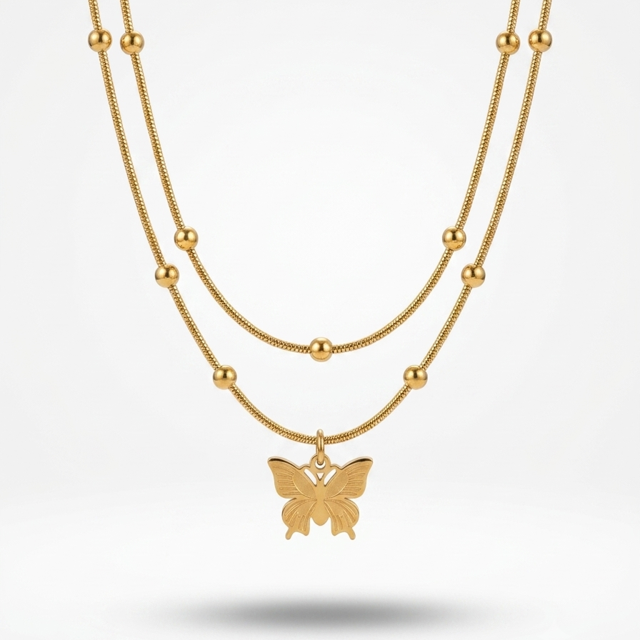 A double-strand gold necklace featuring a fine chain and a beaded chain with a small butterfly pendant, displayed against a clean white background.