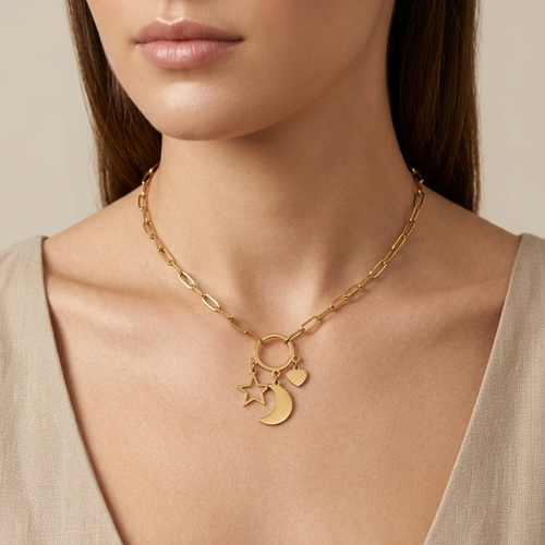 A close-up of a model wearing a gold chain necklace with a ring, crescent moon, and star charm, paired with a beige V-neck top.