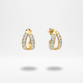 A pair of gold huggie hoop earrings adorned with pavé-set clear stones, shown against a clean white background with soft shadows below.