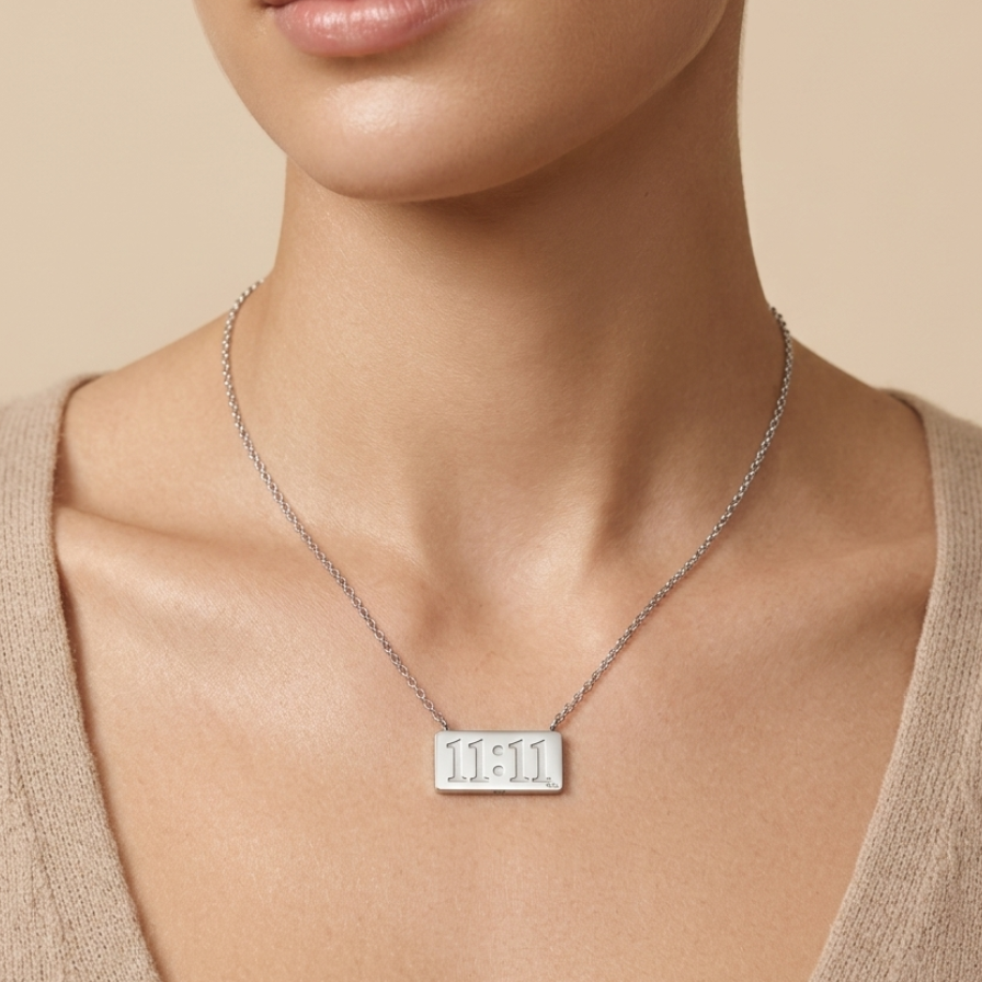 Silver-tone rhodium plated necklace featuring a horizontal rectangular bar pendant engraved with the numbers 11:11  on a neutral background