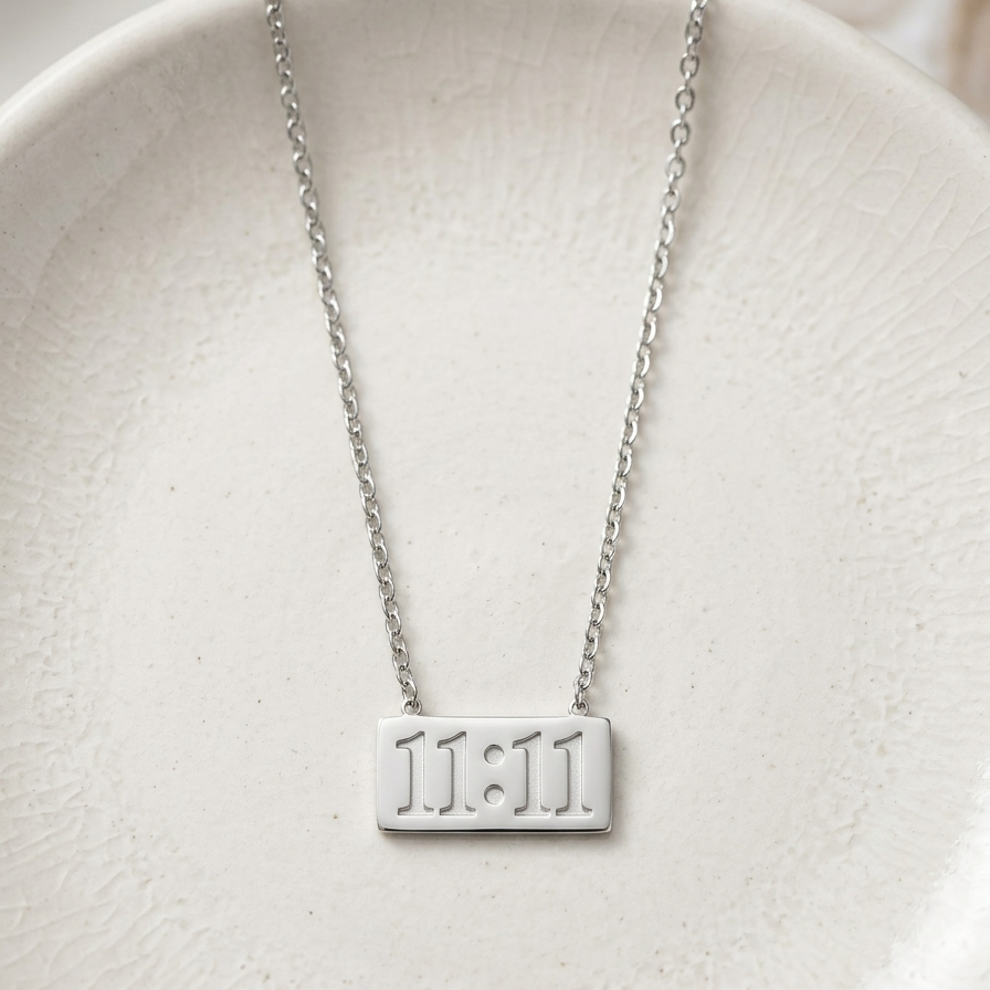 Silver-tone rhodium plated necklace featuring a horizontal rectangular bar pendant engraved with the numbers 11:11.