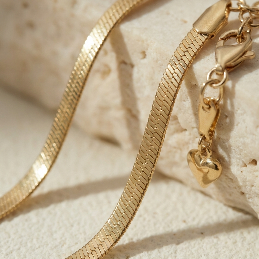 Flat gold herringbone snake chain necklace liquid gold texture waterproof 18k plated on beige silk.