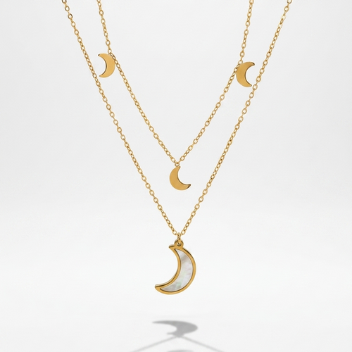 A double-layered gold necklace set featuring crescent moon charms, with one larger gold crescent pendant filled with a white inlay and one smaller gold crescent pendant on the chain, displayed against a clean white background.