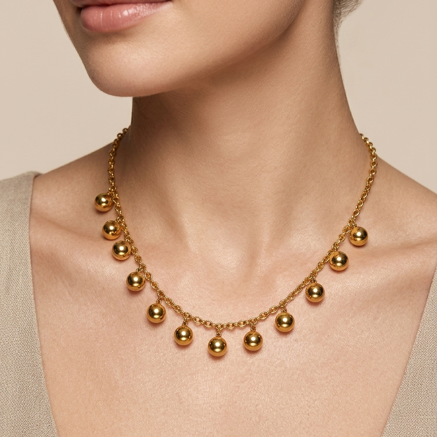 18kt gold plated necklace worn by a model on a beige background.