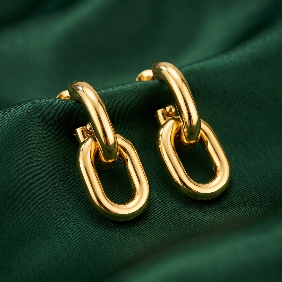 Gold hoop earrings on a green fabric background