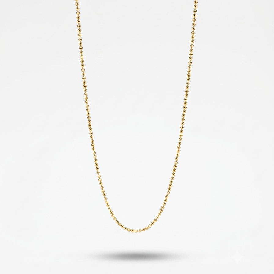 A delicate gold ball chain necklace suspended against a clean white background with a soft shadow beneath.