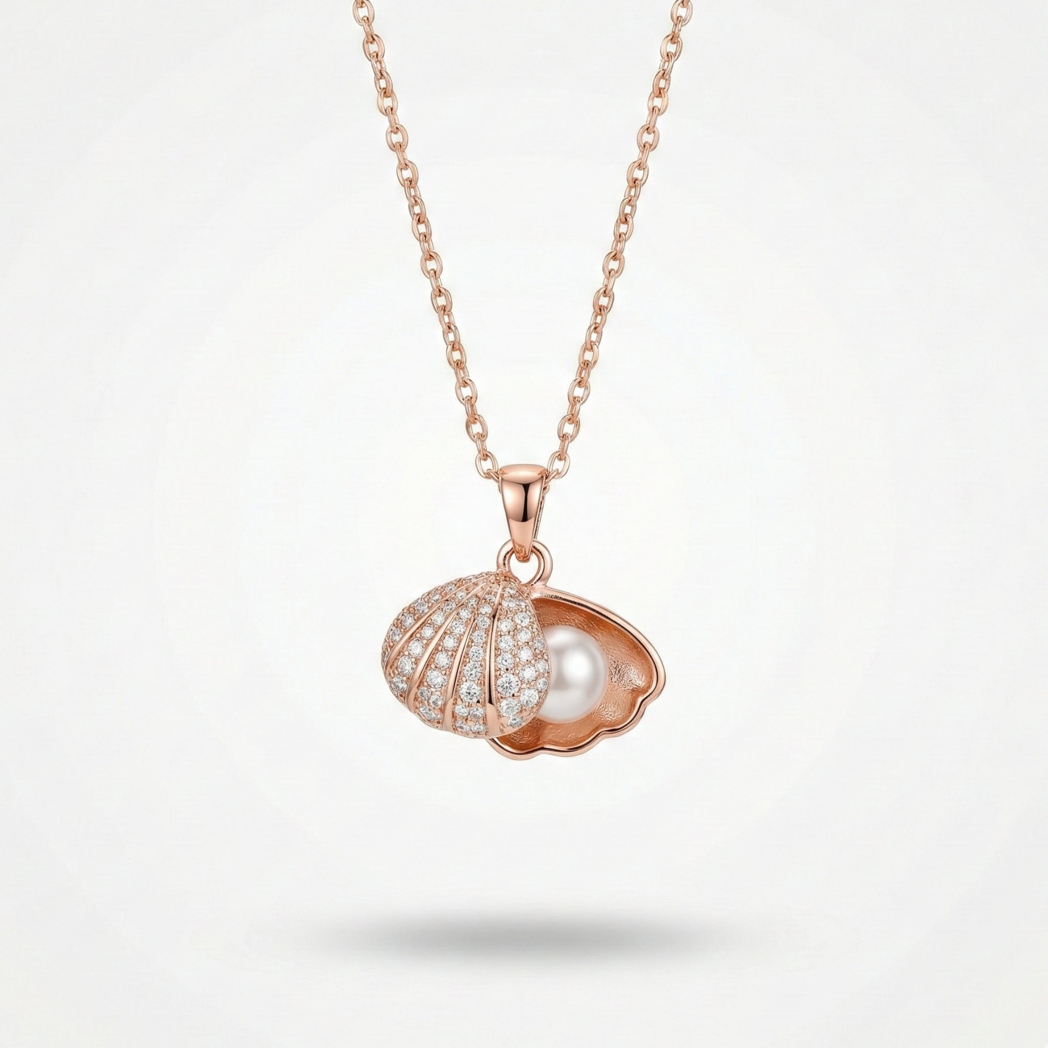 Rose gold necklace with a shell and pearl pendant on a light gray background