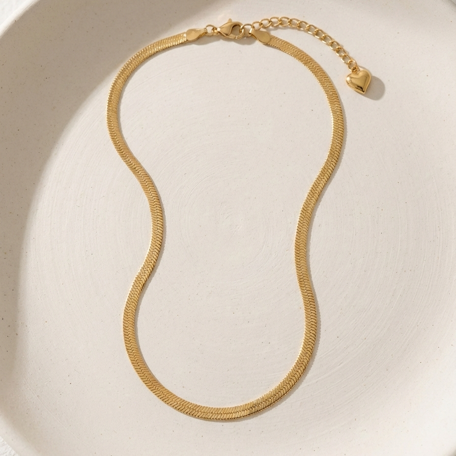 Flat gold herringbone snake chain necklace liquid gold texture waterproof 18k plated on beige silk.