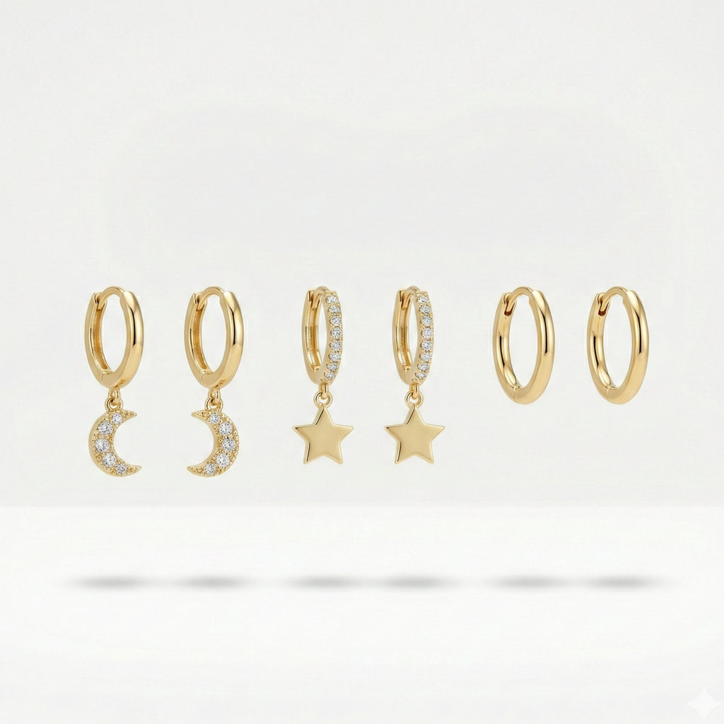 Set of gold huggie earrings with dangling star and moon charms on packaging card.