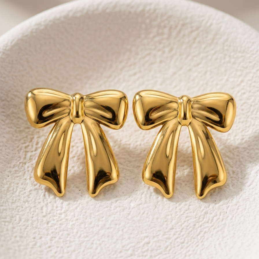 18kt gold plated bow-shaped studs on a white background.