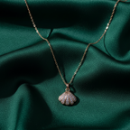 Necklace with a shell pendant on a green fabric background