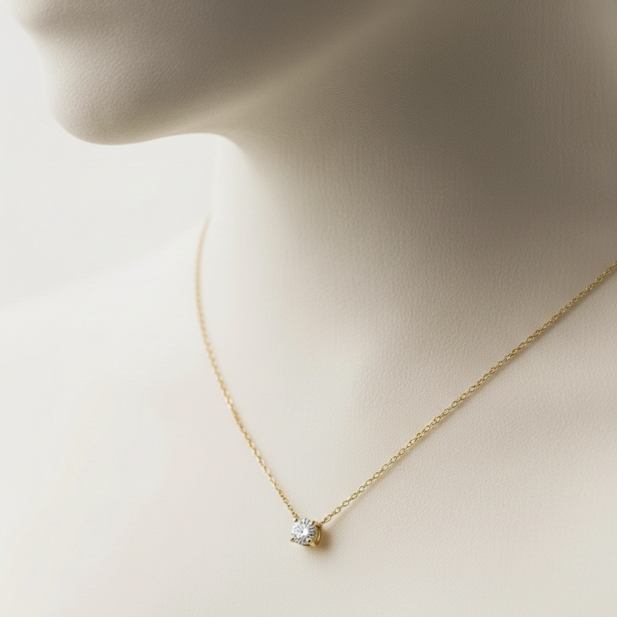 Single round crystal solitaire pendant necklace on white fabric background.