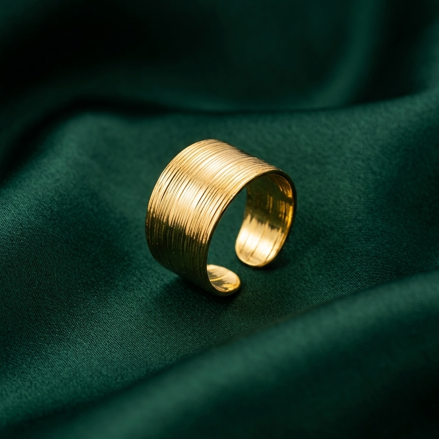 18kt gold plated wide grided ring on a green fabric background
