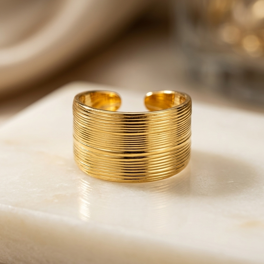 18kt gold plated ring with ribbed design on a marble surface