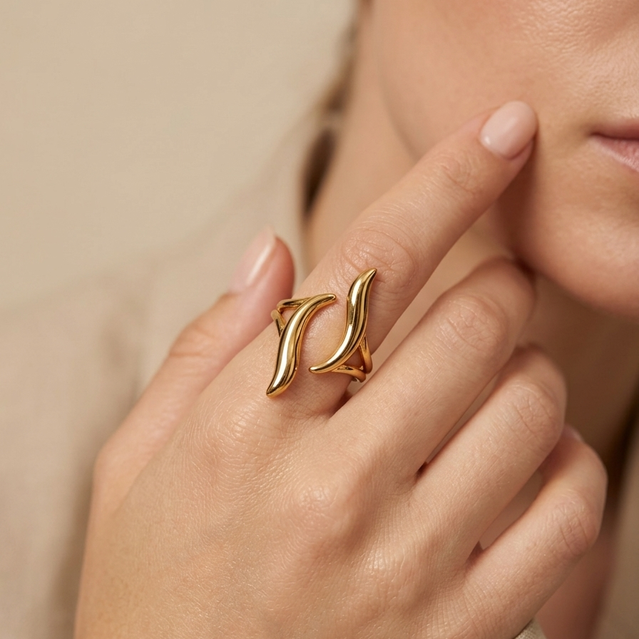 18kt gold plated ring on a finger against a neutral background