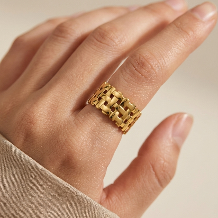 18kt gold plated woven mesh ring on a hand against a neutral background