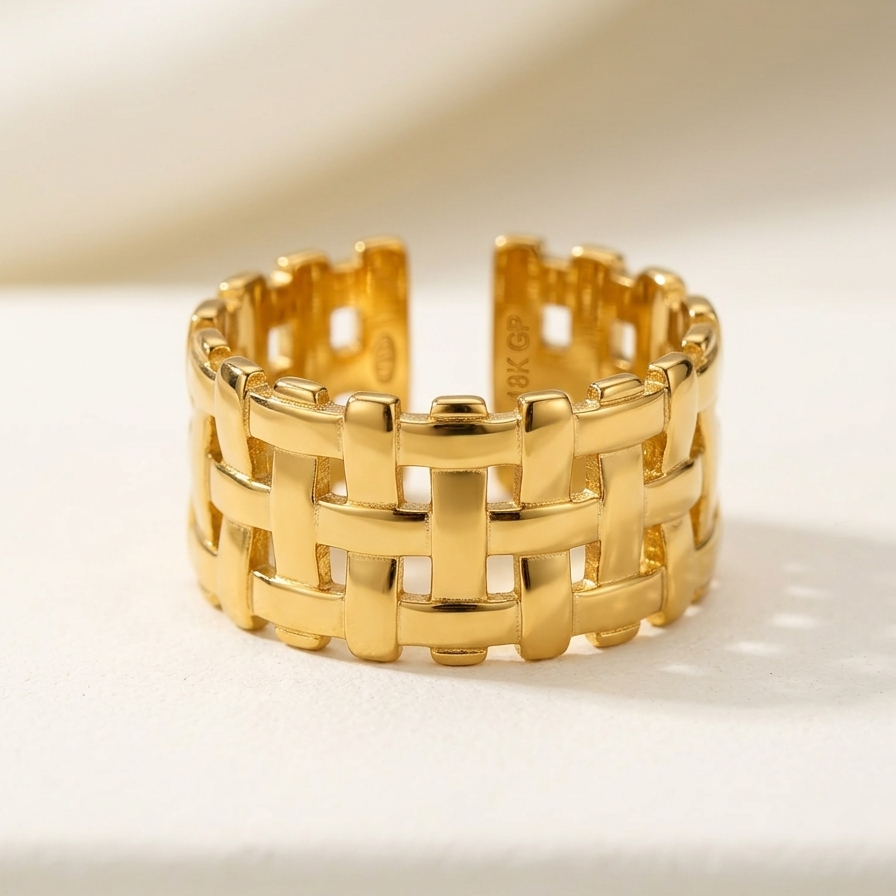 18kt gold plated woven mesh ring on a light beige background