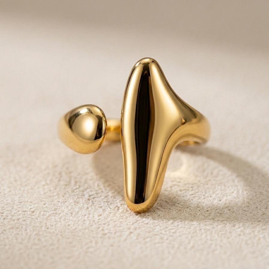 18kt gold plated ring with a unique design on a beige background